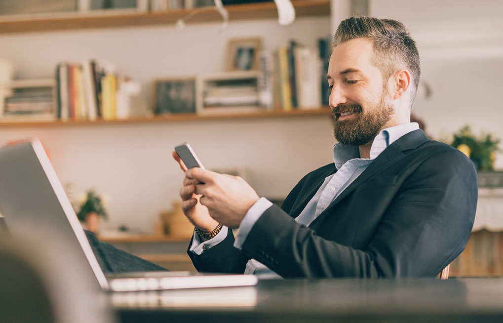 A businessman texting on his phone